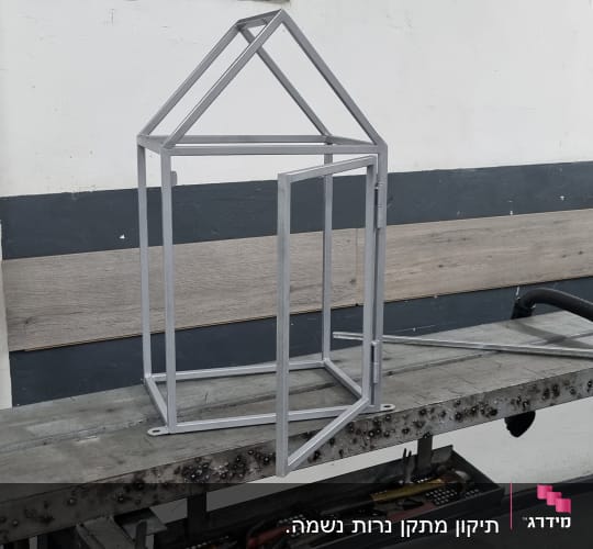 מסגרת מתכת בצורת בית על שולחן עבודה